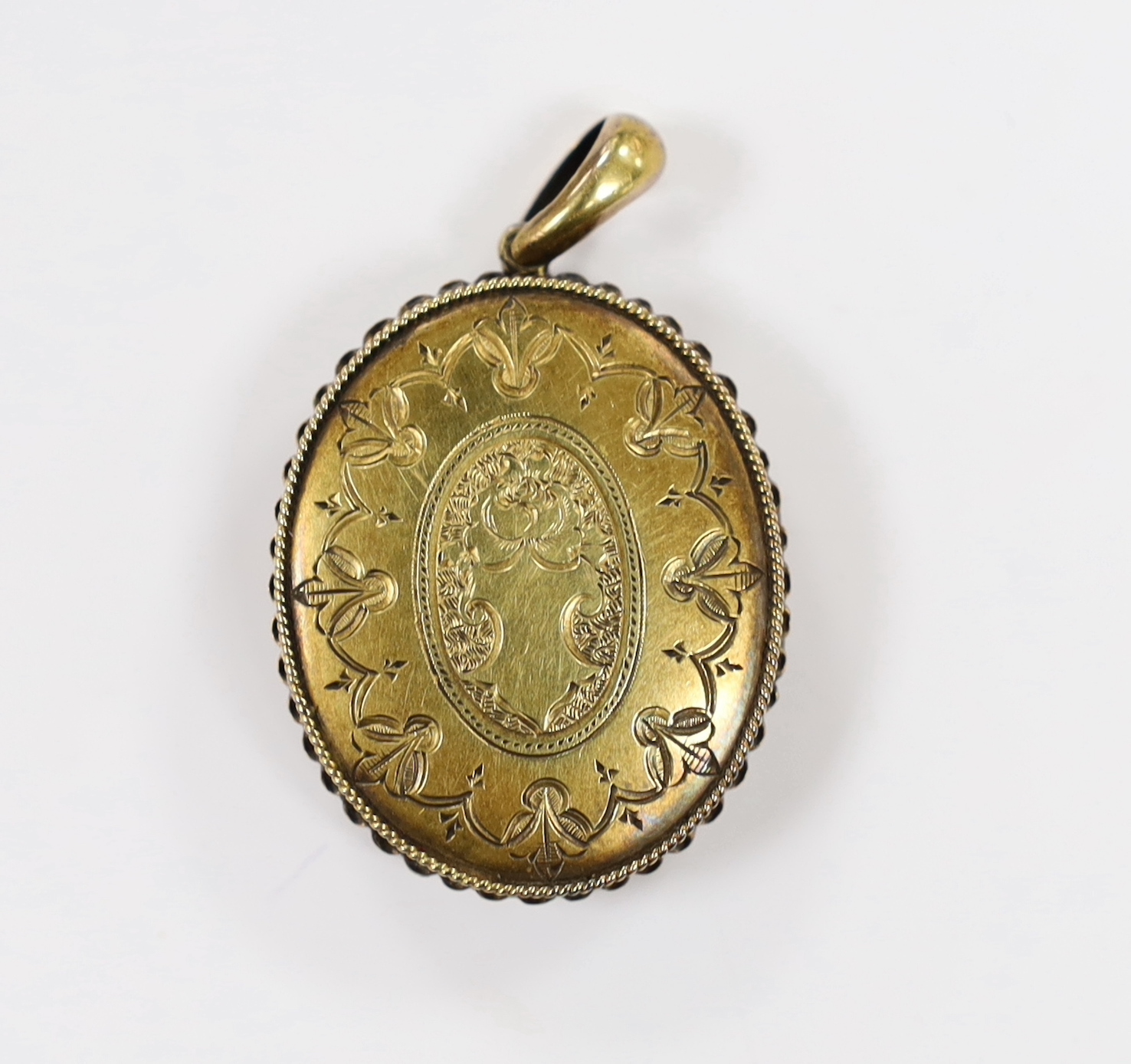 A Victorian engraved yellow metal, enamel and seed pearl set oval locket, overall 45mm, gross weight 14.1 grams.